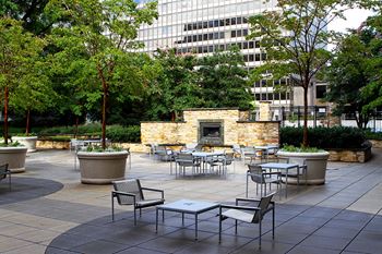 Central outdoor lounge with stone fireplace & multi-level terrace featuring a formal garden